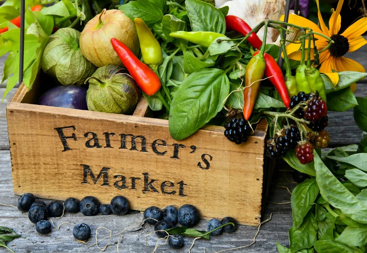 A picture of a wooden box filled with fruits and vegetables.