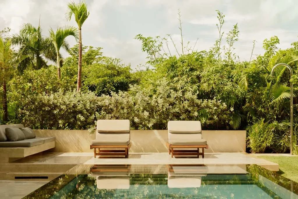 plush loungers surround a sleek pool in a tropical oasis