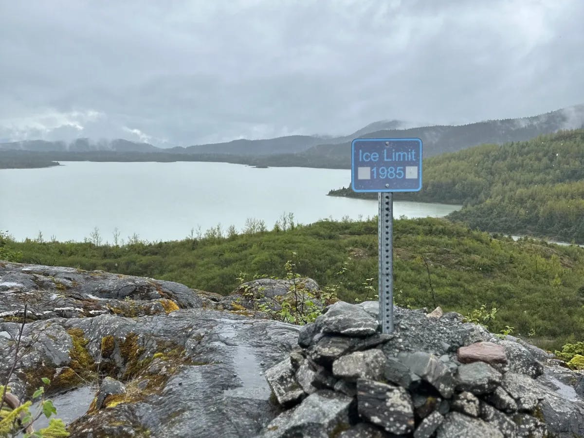 Hiking to a glacier with a board stating "Ice Limit 1985"