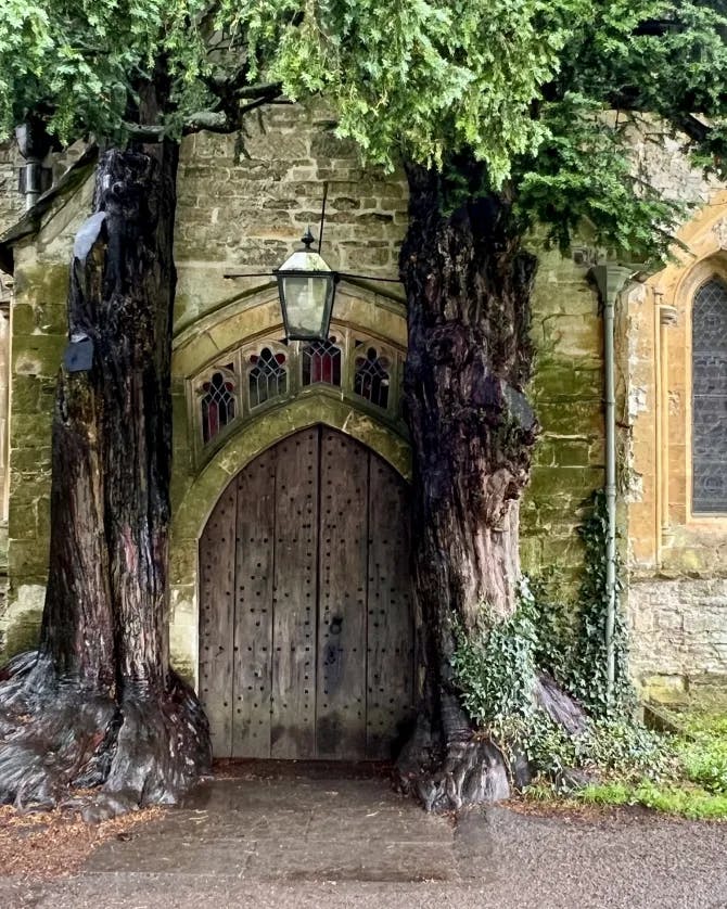 Picture of St Edward's Church with two tree trunks surrounding the entrance