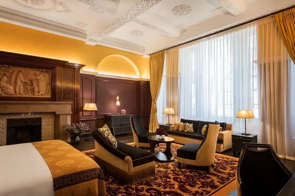 A gold, maroon and black color palette paints an elegant suite at L’oscar London