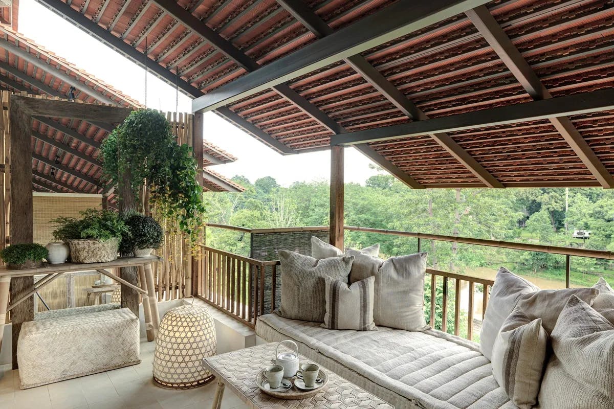 a luxe terrace with a plush white couch overlooking the jungle