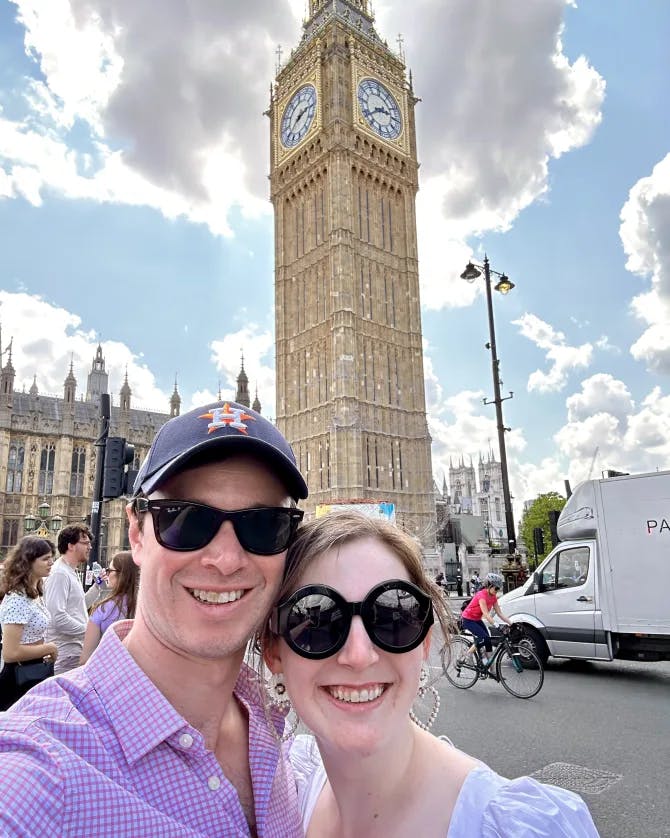 Couple posing in front of a clock tower