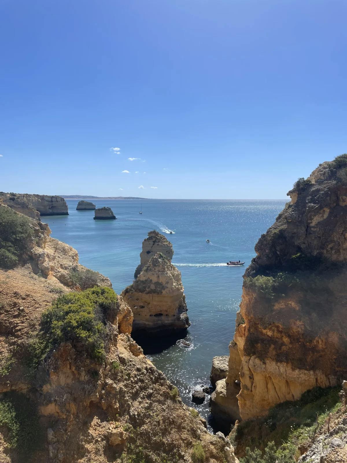 A point of view shot from atop a cliff looking down at isolated rocky islands in the middle of the Atlantic Ocean. 