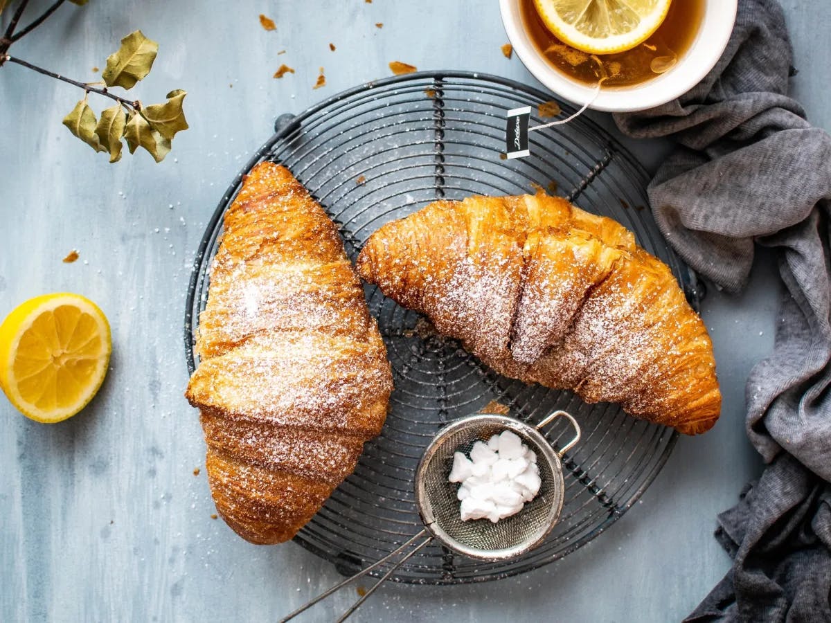 Two croissants in a plate on table. 