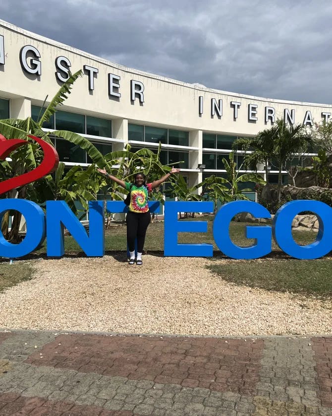 Travel advisor posing in front of a large sign reading "I love Montego Bay"