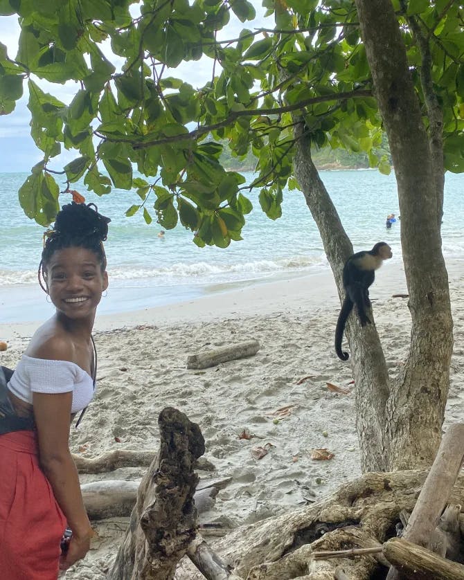 Cameisha Cotton posing for a picture by a baby monkey