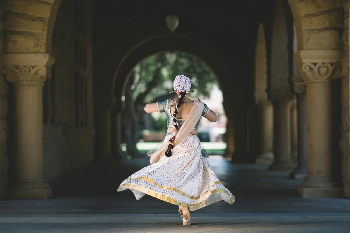 A woman in traditional clothing dancing in the hallway.