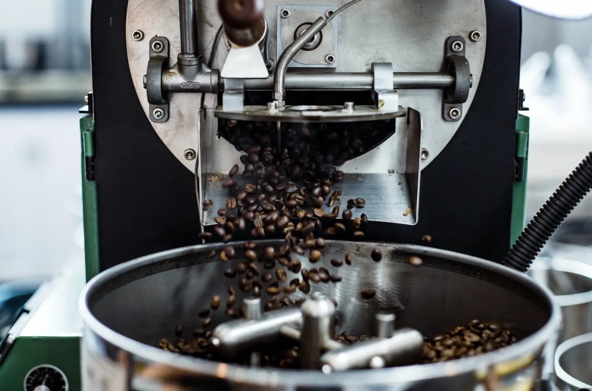 A coffee machine with coffee beans pouring out of it. 