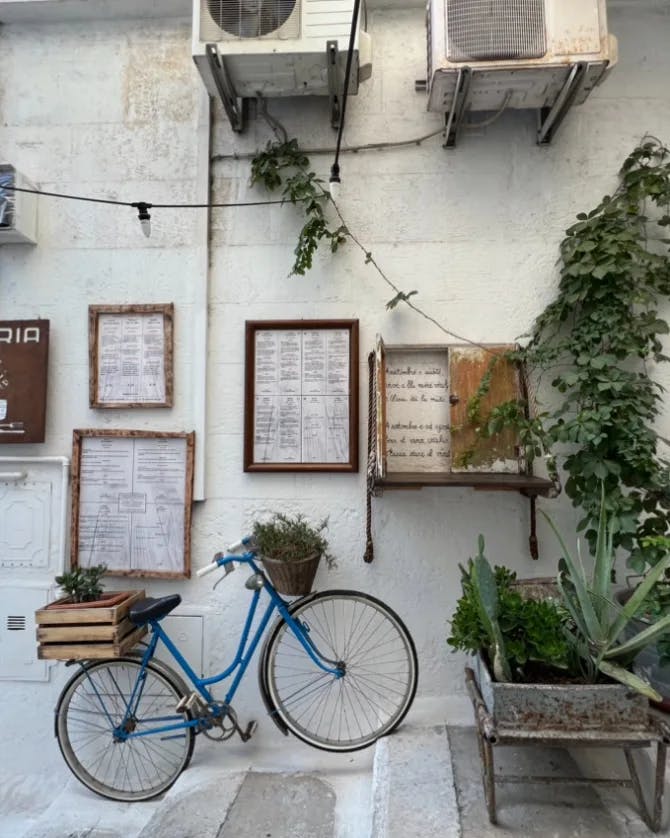 Street with cycle and frames on wall. 