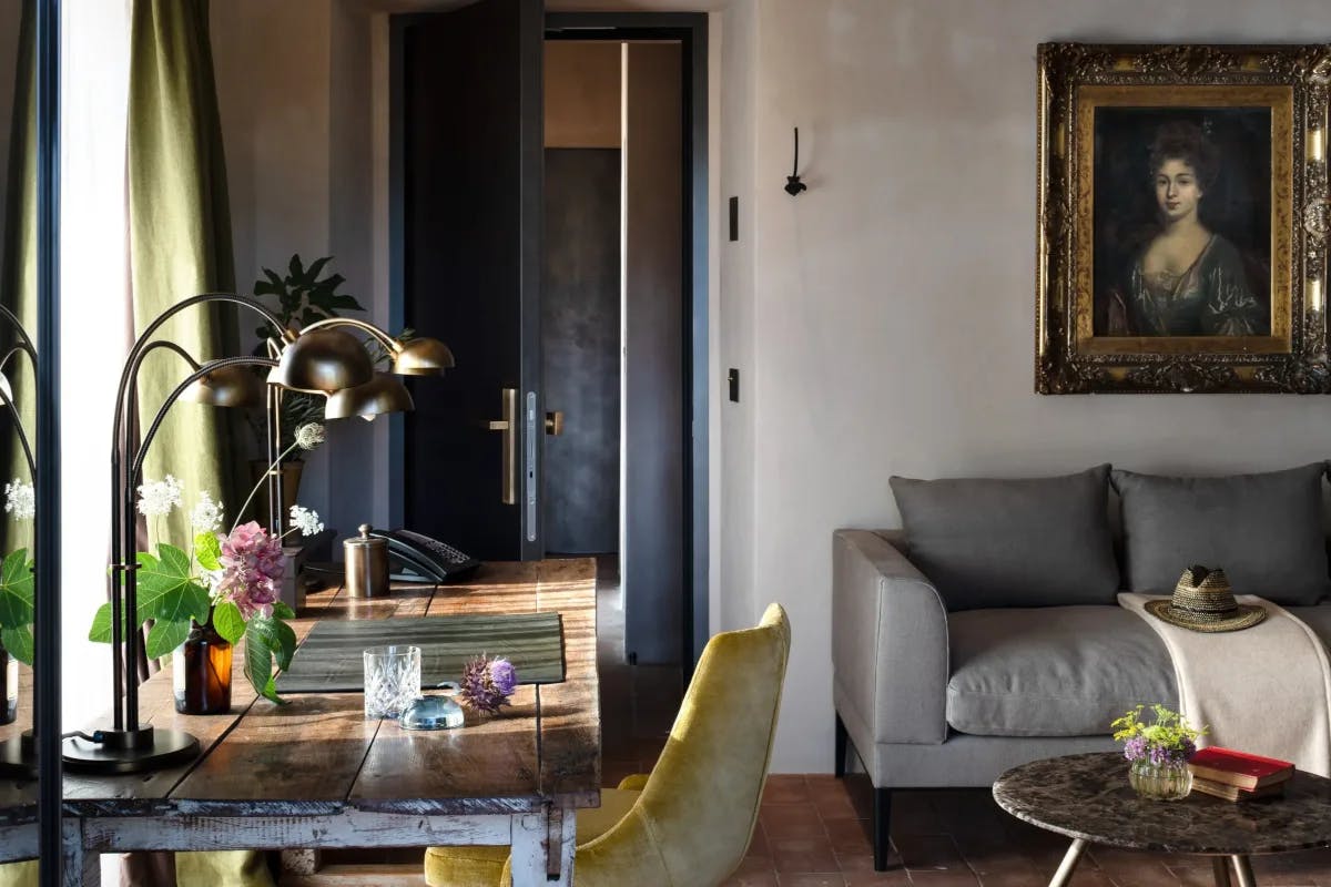 a rustic wooden desk in a living room with a framed portrait of a woman