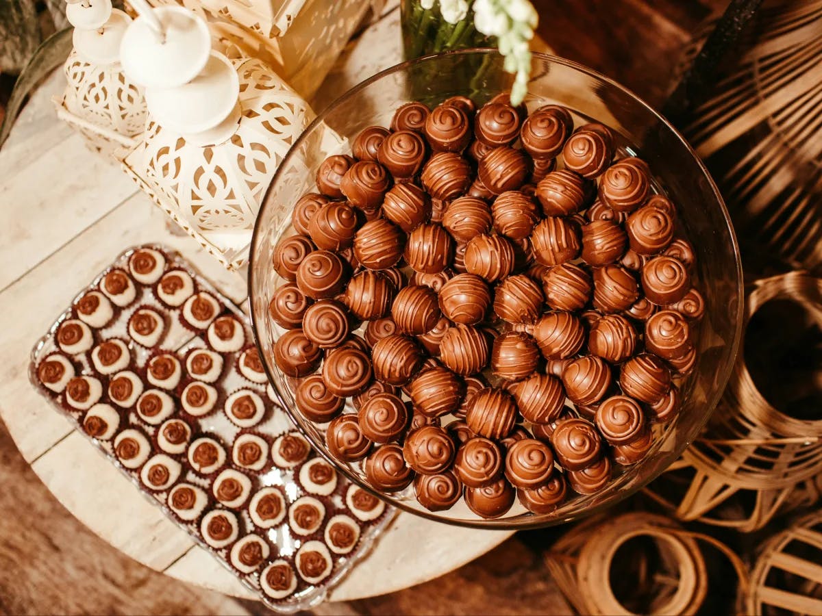 An aerial view of a glass bowl of chocolate candy balls.