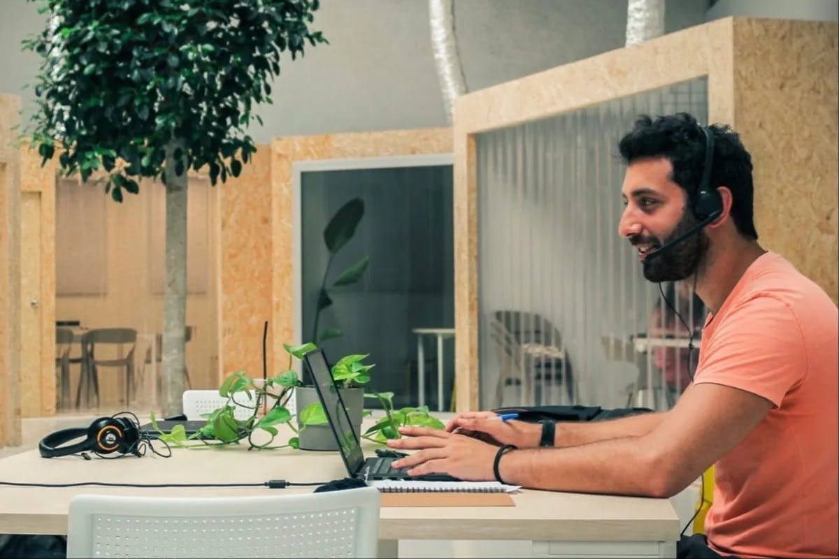 A patron works and enjoys the sunlit space and greenery inside Itnig Coworking.