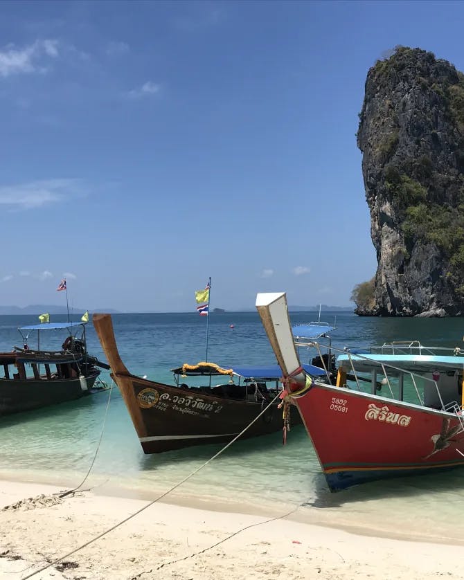 View of boats resting by the seaside and sea stack