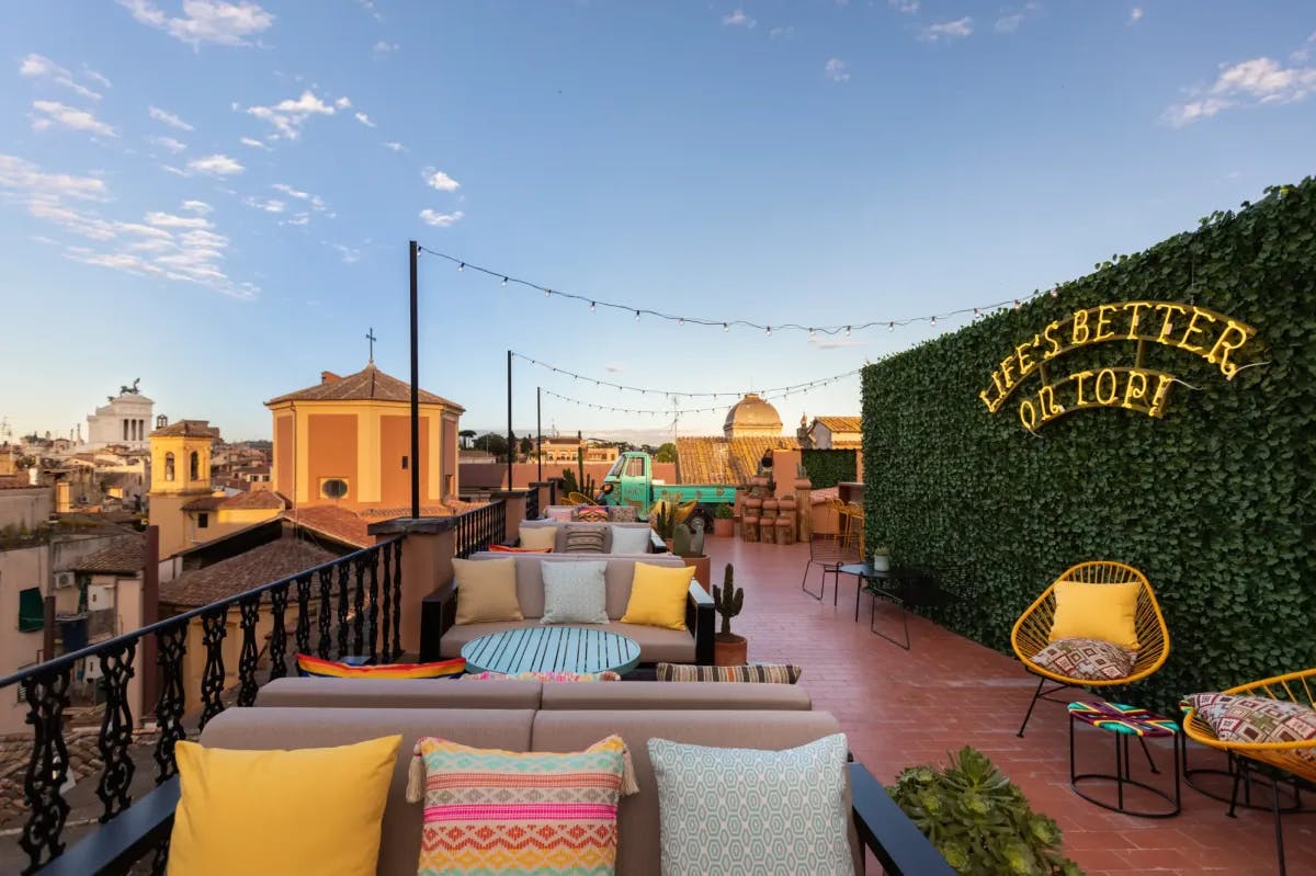 Vibrantly decorate rooftop terrace in Rome, with historic skyline visible