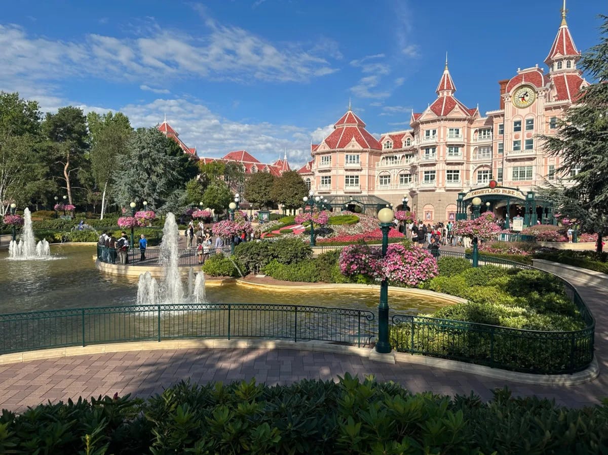 A garden with water body, fountains and a castle. 