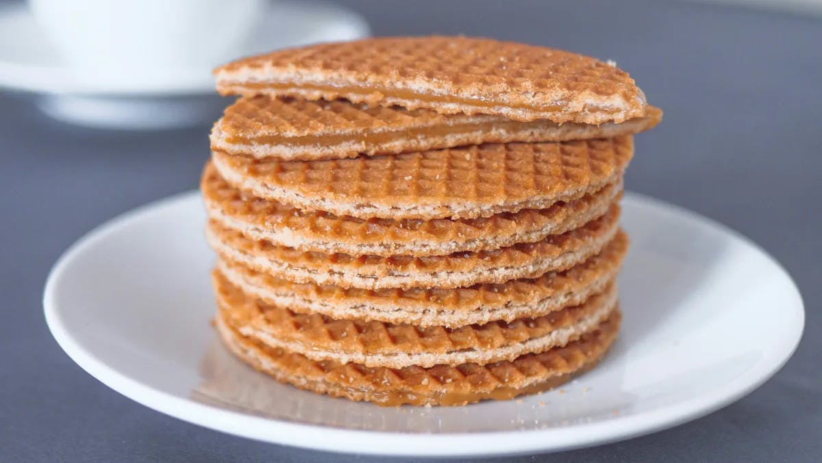 A stack of stroopwafels on a white plate.