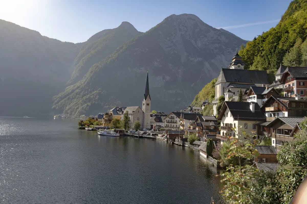 A lake with houses and mountains at its shore on a sunny day.