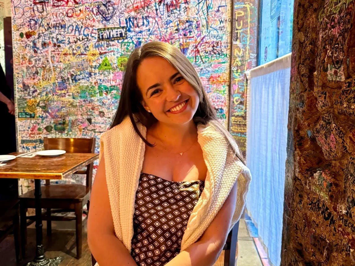 A woman sitting and smiling in a restaurant.