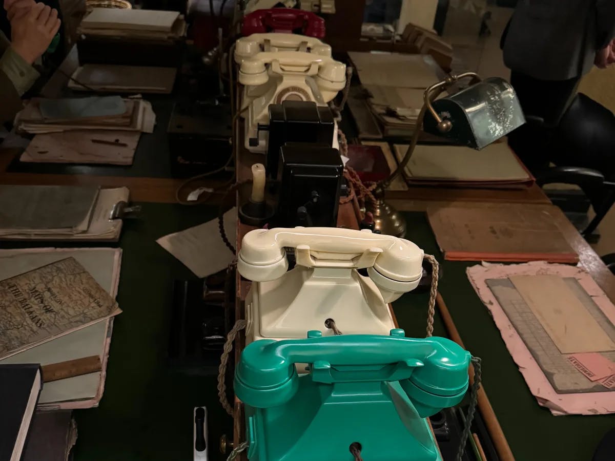 A picture of old telephones and letters is laid on a brown table.