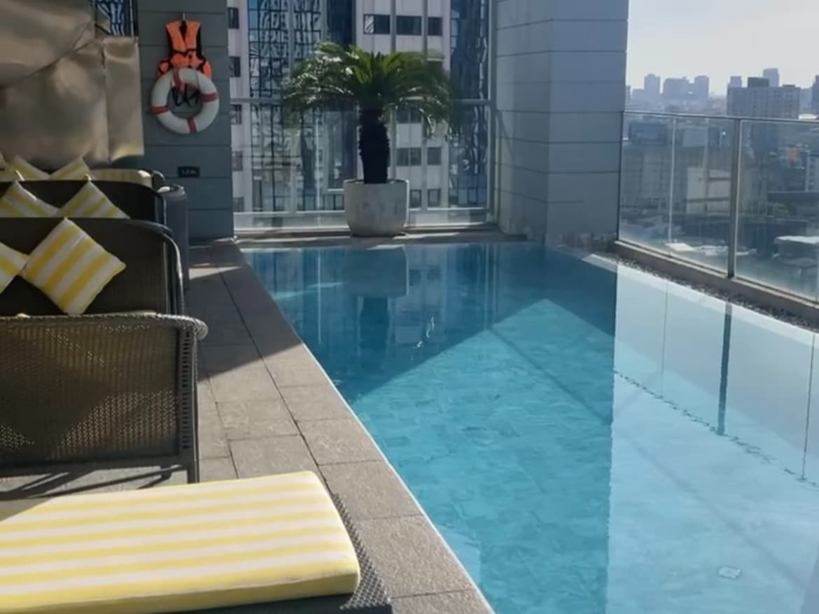 A swimming pool on a balcony  with a city view