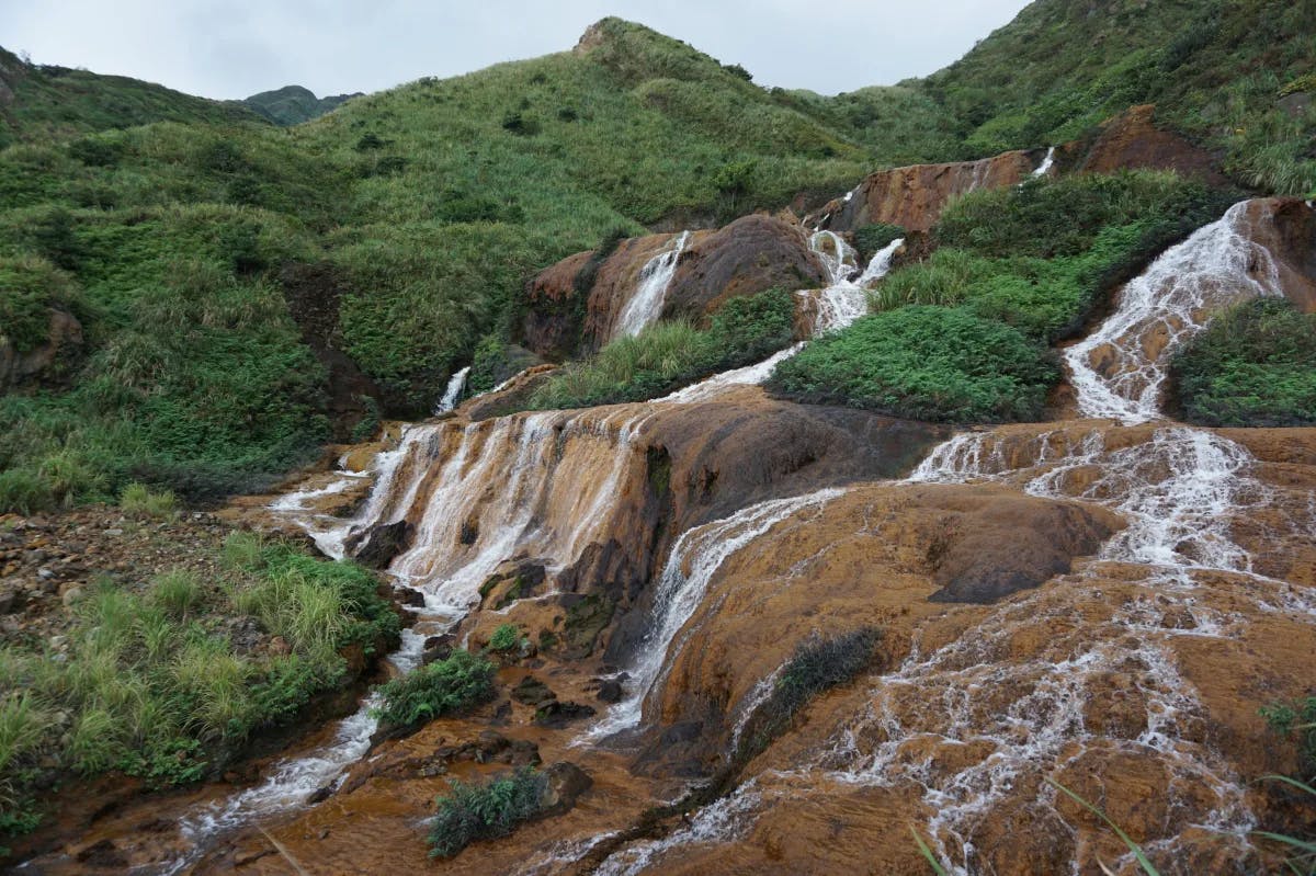 Shifen "Golden" Waterfall with cascading waters tinted by minerals, creating a stunning golden hue.