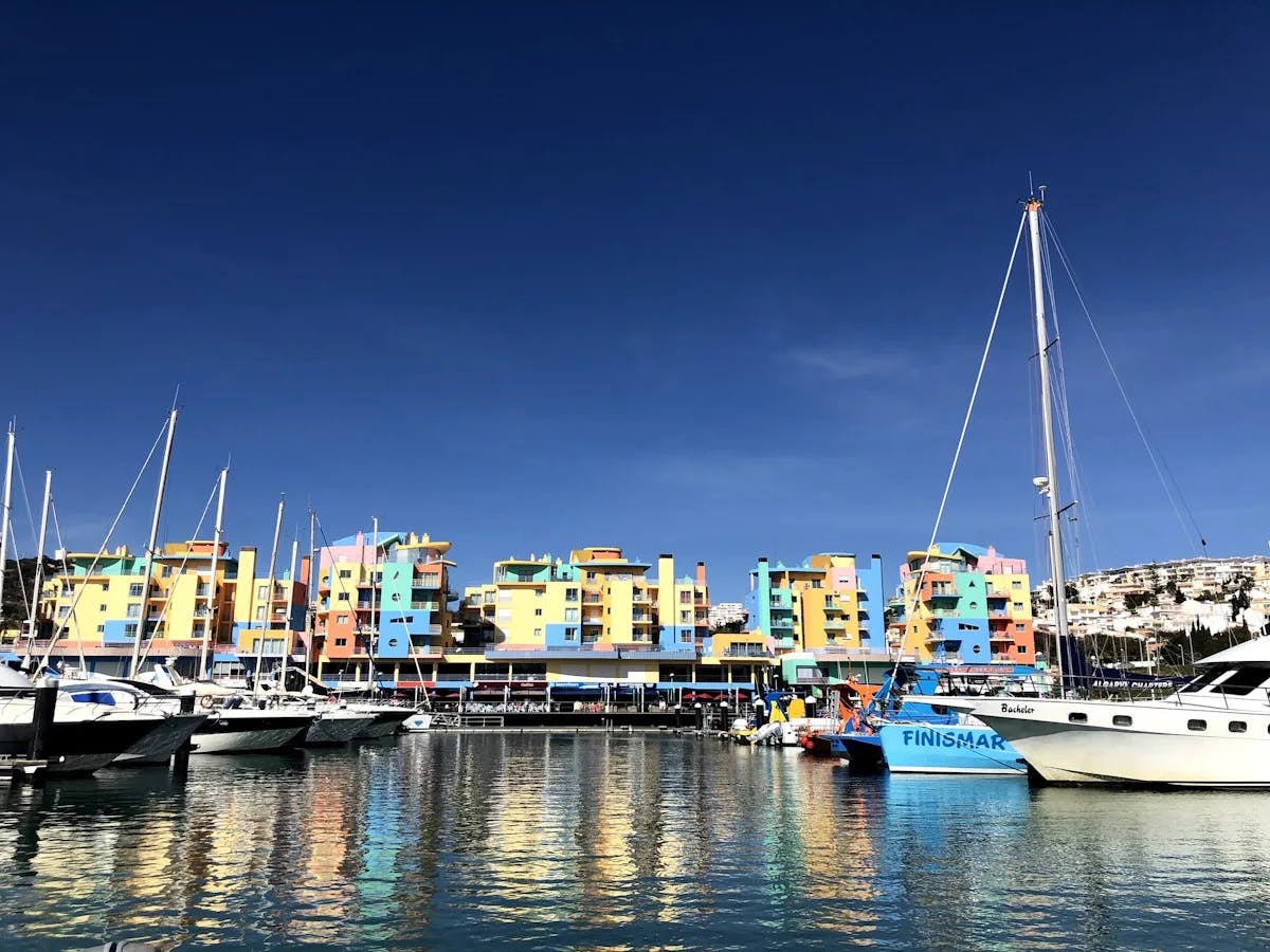 A boat harbor next to city buildings during the daytime