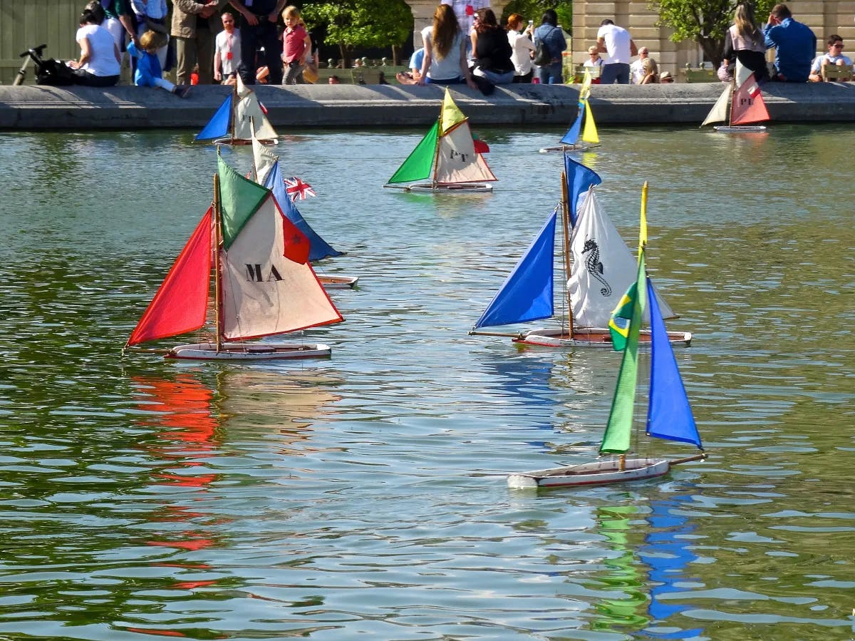 Kids making paper boats and placing on water