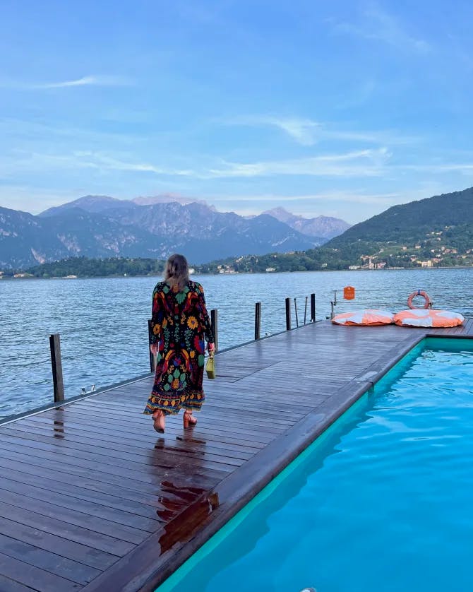 Picture of Gianna walking along the pool with beautiful lake view