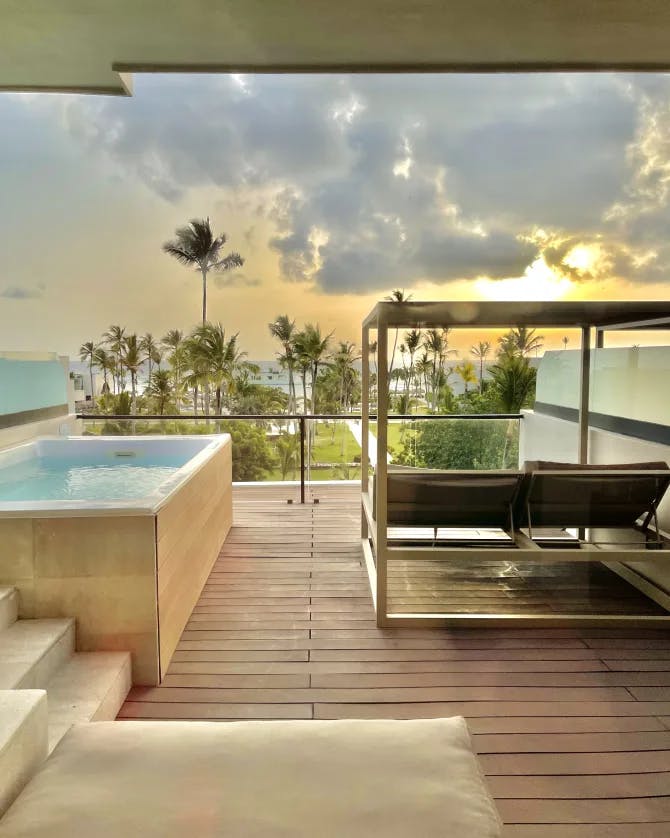 An image of a hotel room deck with a private pool and a lounger for relaxing during the daytime. 