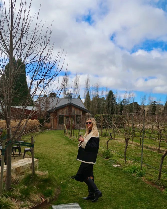 Advisor standing in a vineyard and holding a glass of wine