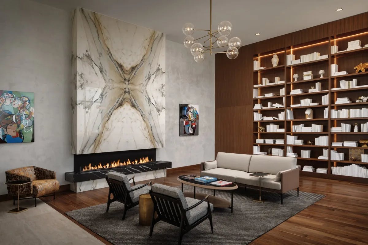 modern lobby with marble fireplace, seating area and tall bookshelves