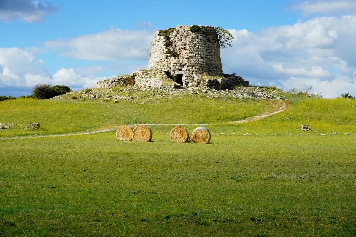 A rocky structure on a green hill on a sunny day.