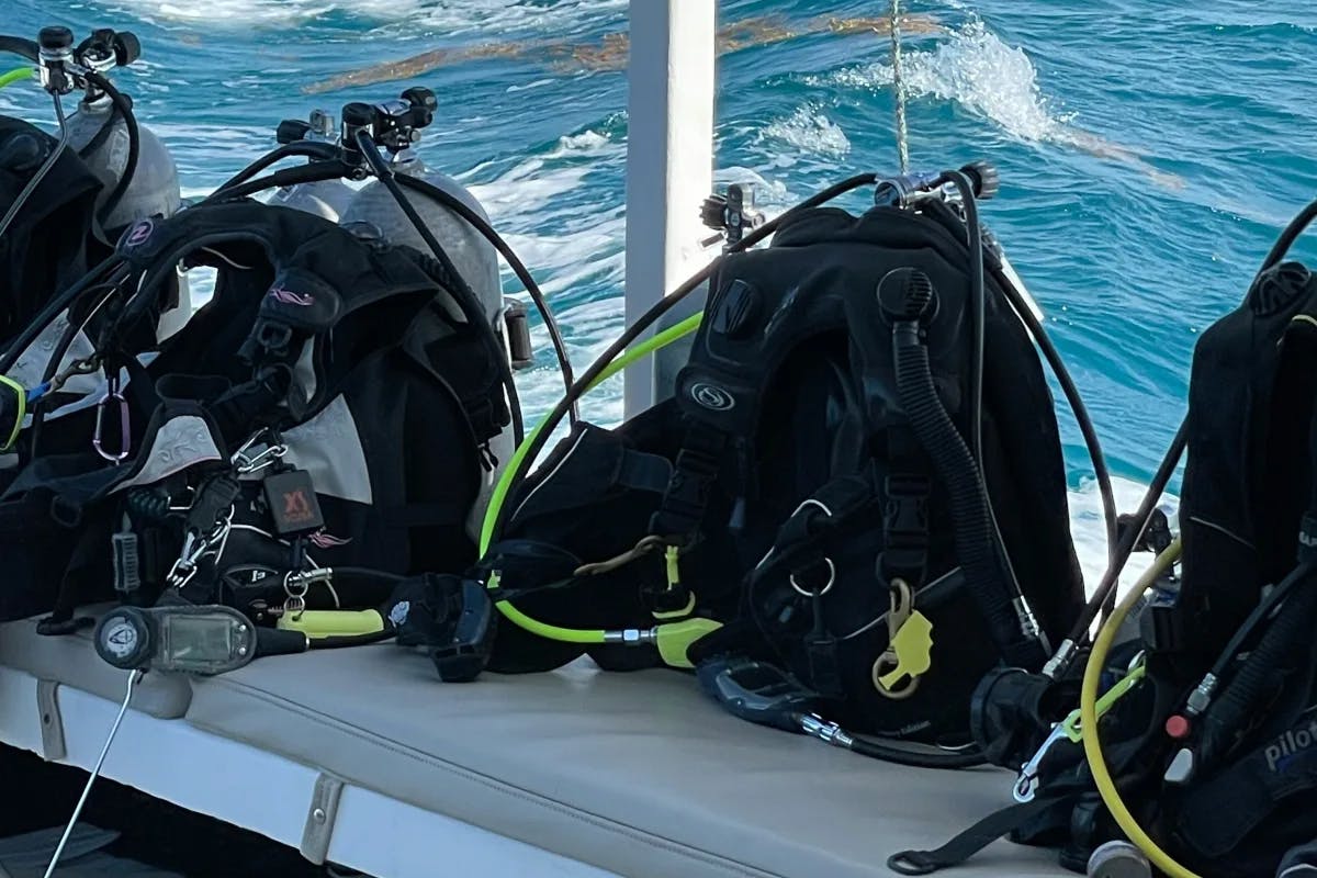 Scuba equipment on the edge of a boat overlooking the water.