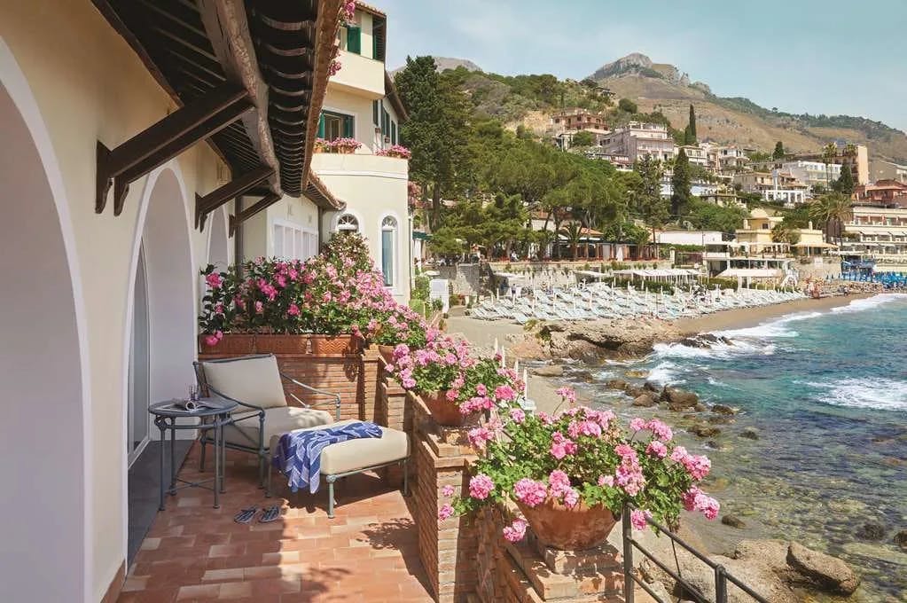 From a small, private patio lined with flowers, guests can see Taormina's gorgeous beach