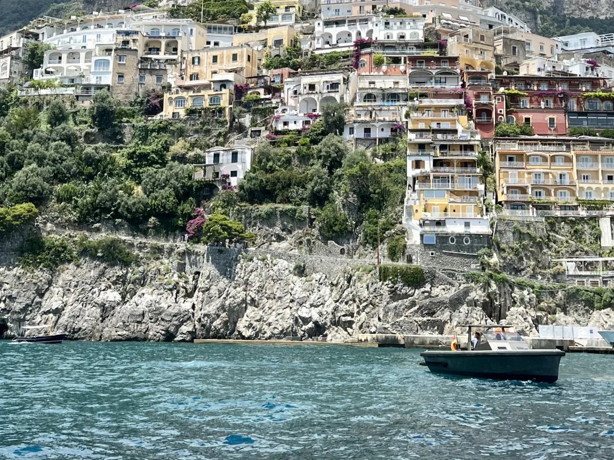 Many houses on the side of a hill in front of the water