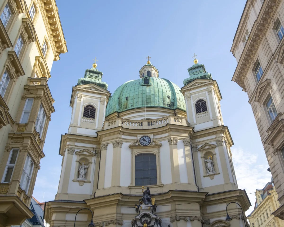 A white and gold building with a teal dome during daytime.