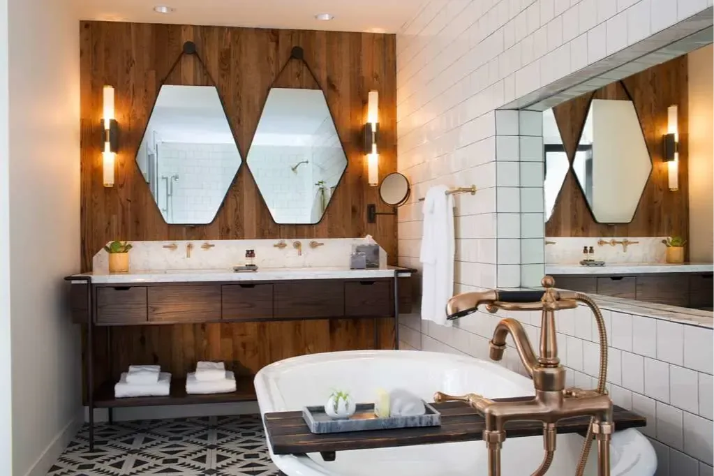 A vintage-styled soaking tub sits before an industrial-meets-contemporary vanity bathroom counter