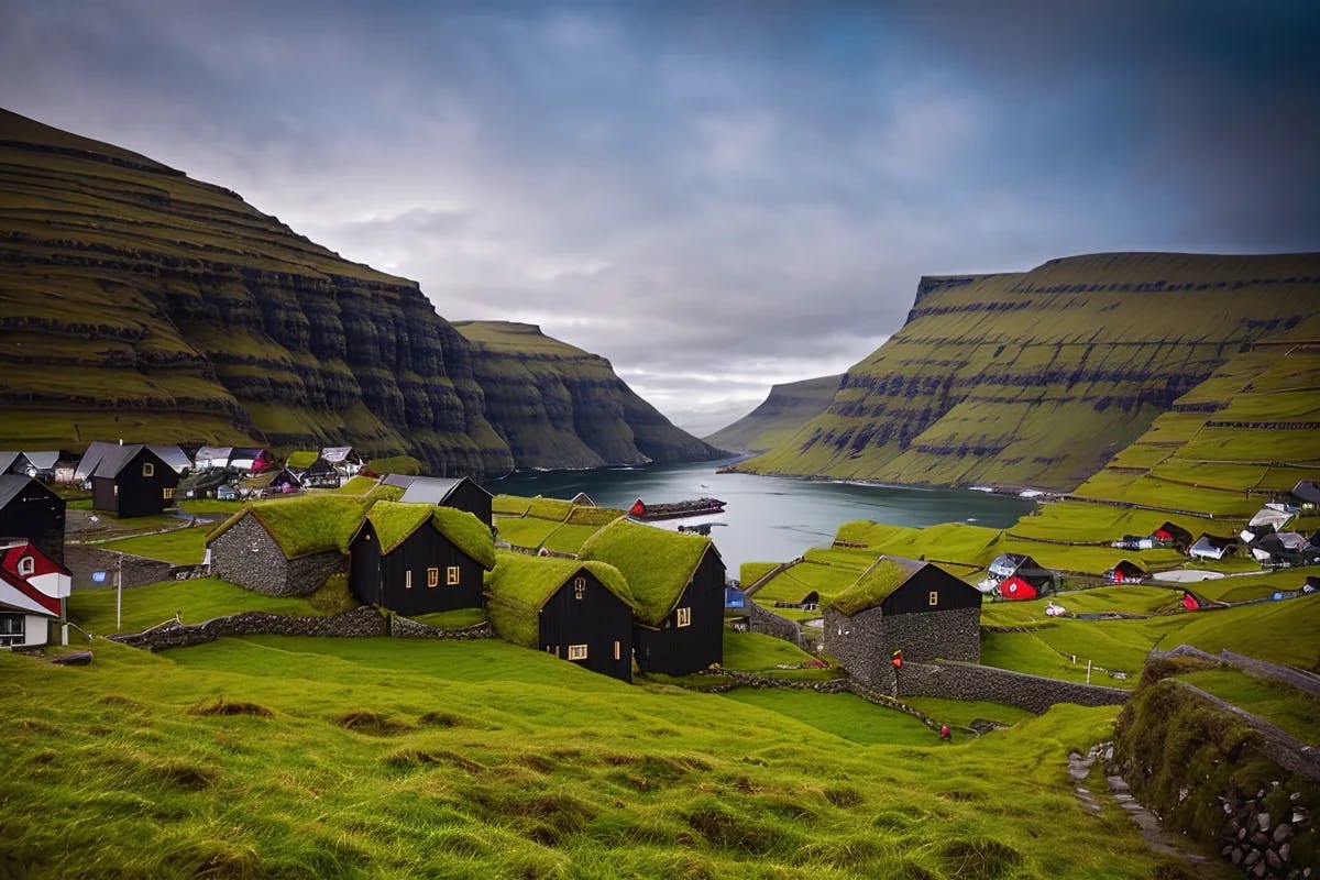 Houses with grass-covered roofs in front of a valley of water