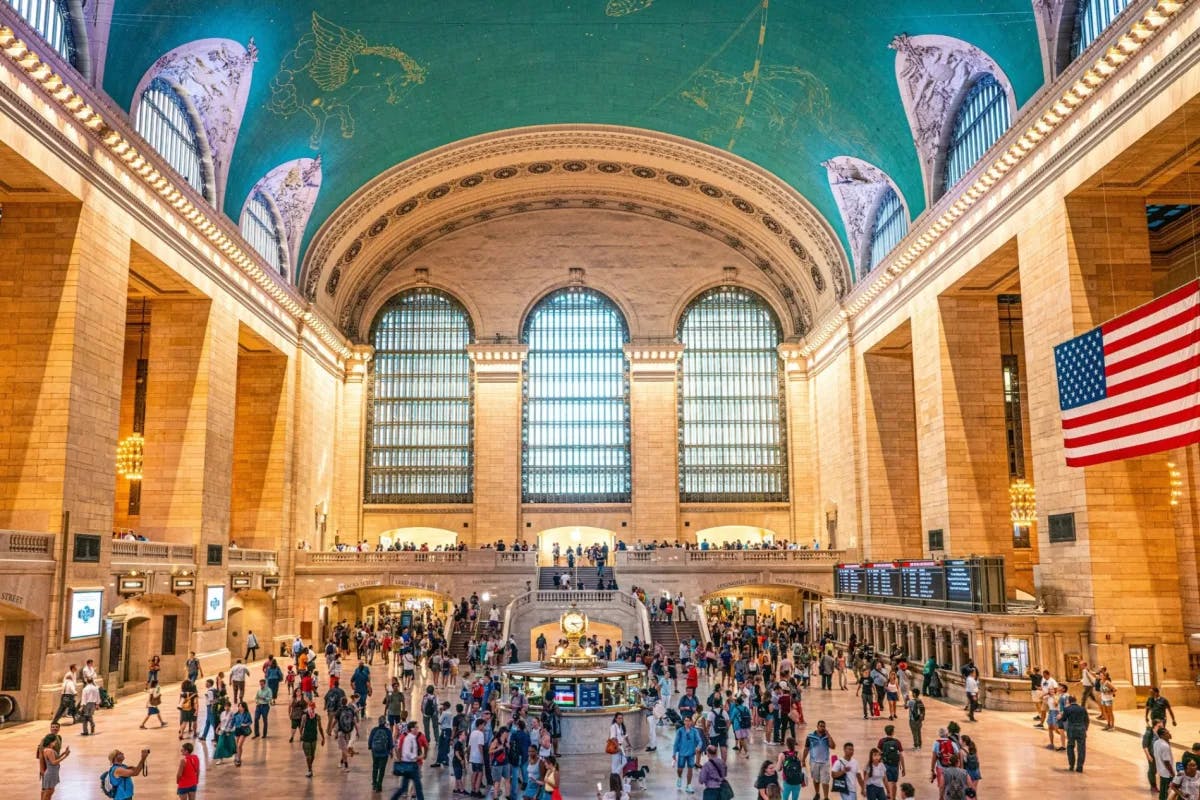 train hall with high arched ceiling and columns with people walking around