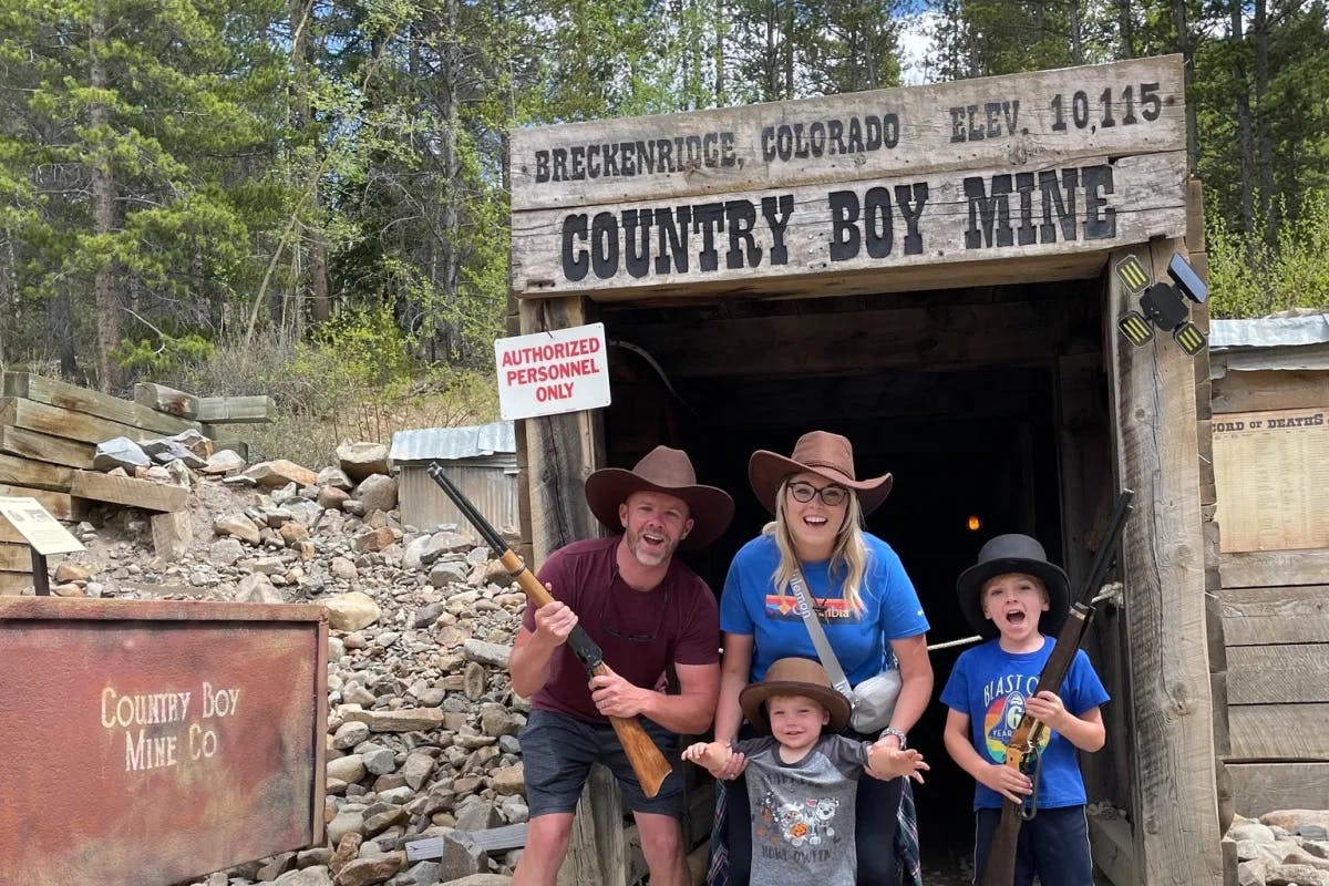 A family posing for a photo with props under a sign