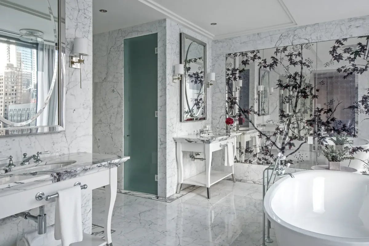 a white marble bathroom with a deep oval tub