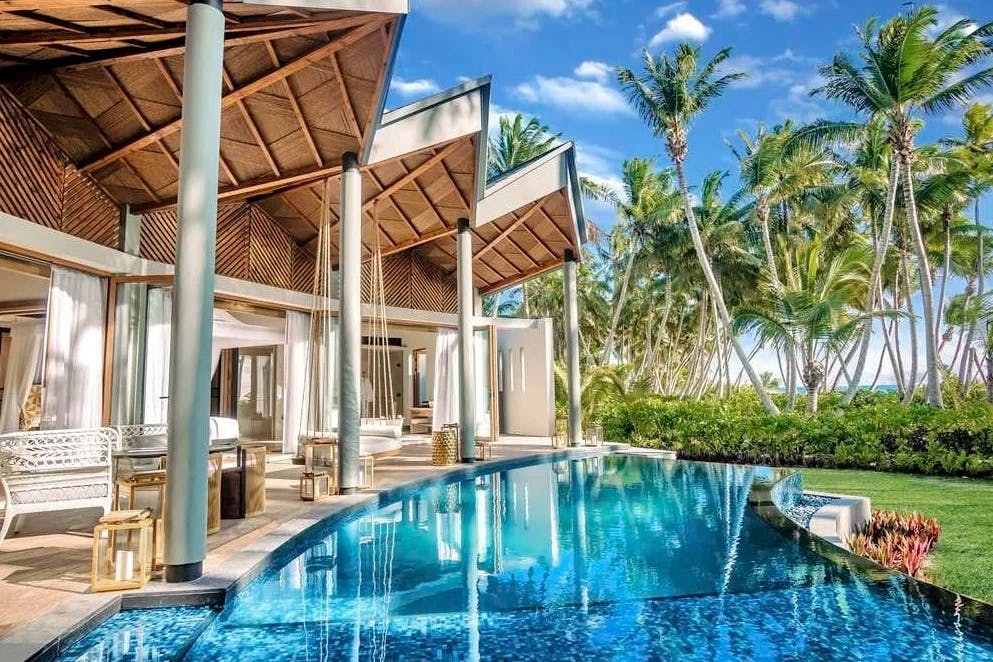 angular hotel exterior with palm trees and blue infinity pool