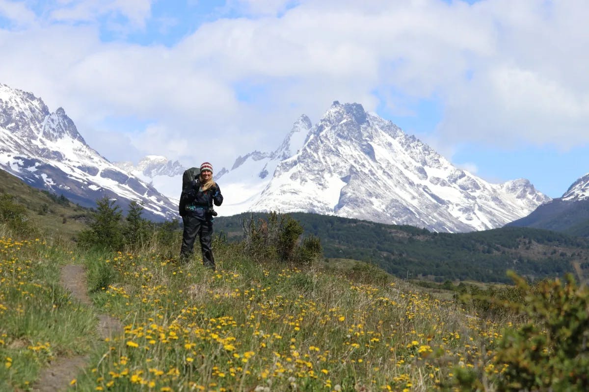 Advisor hiking with snow mountains in the distance.