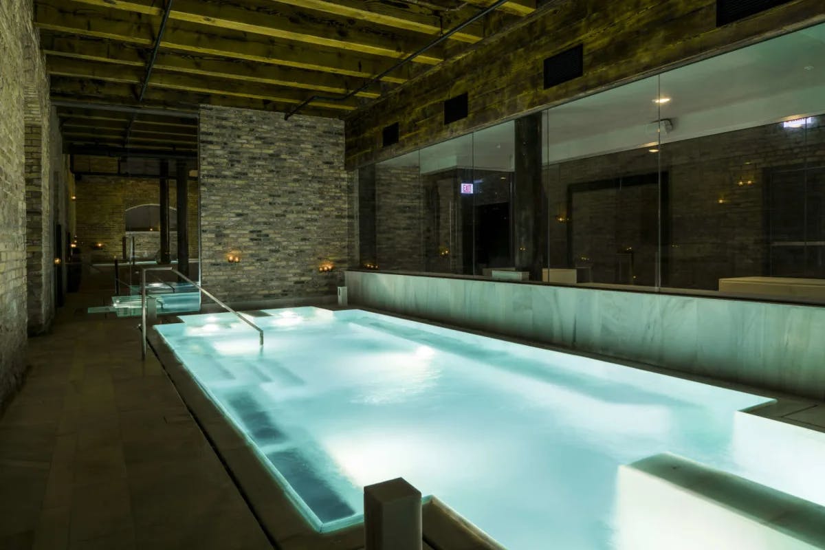 An indoor pool in a dimly-lit room