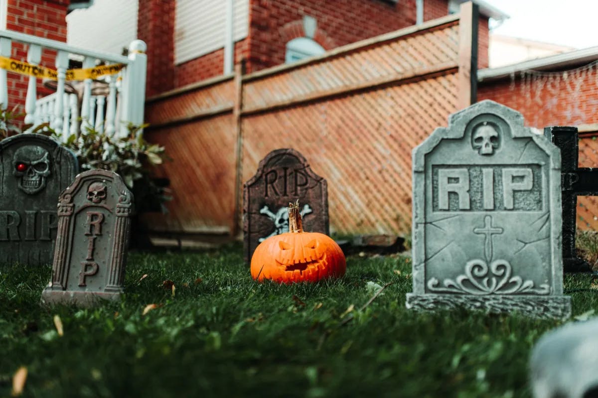 A cemetery with pumpkin and tombstones. 