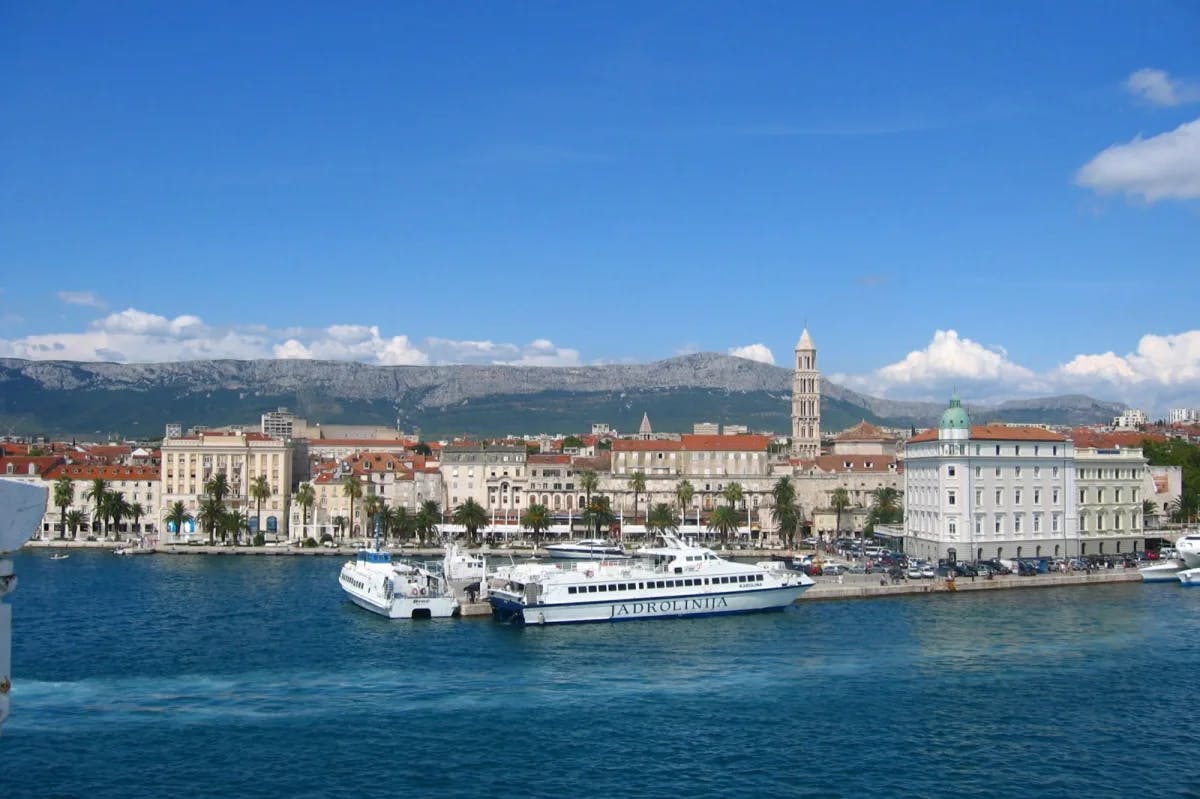 Ferry on the water near a historic coastal town.