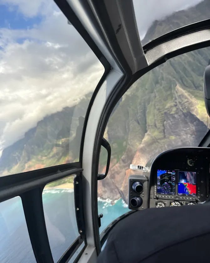 helicopter ride with a lush island in the distance and the ocean below.