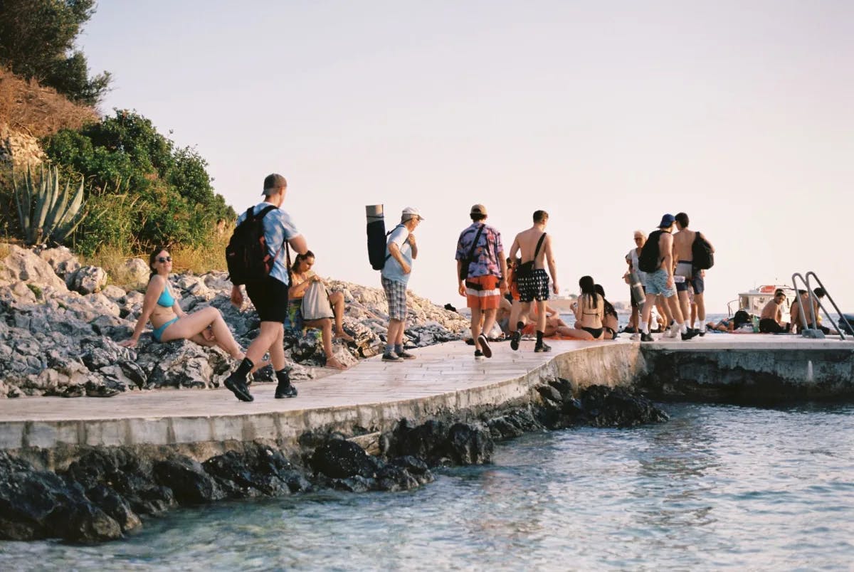 People walking near waterbody during day time. 