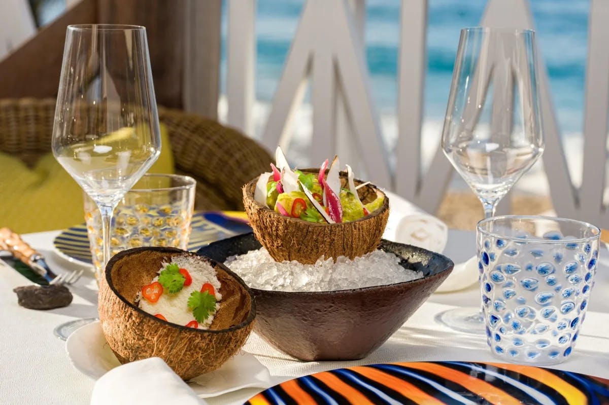 colorful dish served in a coconut bowl set on ice on a colorful table